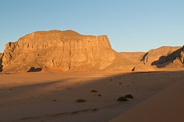 Fototapeta na wymiar View of the rock formations Playa of Moul Naga at sunrise of the Tadrart Rouge rocky mountain range in Tassili n Ajjer National Park. Sahara desert, Algeria, Africa.