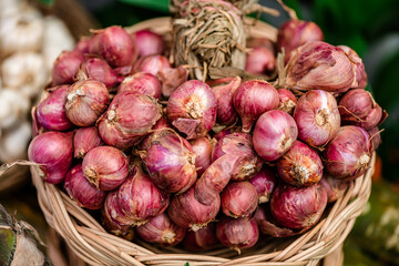 Dry fresh Red Onion pile up on a wooden basket for sale in the market