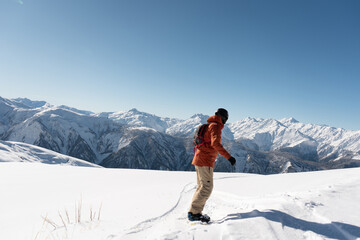 Naklejka na ściany i meble snowboarder freerider riding on an unprepared snow field on board in high mountains