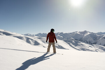Fototapeta na wymiar snowboarder freerider riding on an unprepared snow field on board in high mountains