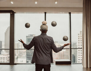 african american businessman with a bun stands with his back to the viewer in an office