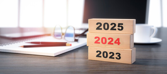 3D render of a stacked wooden blocks with year number 2023 2024 2025 on a office workplace...