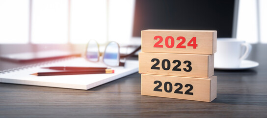 3D render of a stacked wooden blocks with year number 2022 2023 2024 on a office workplace background - 3D illustration - Powered by Adobe