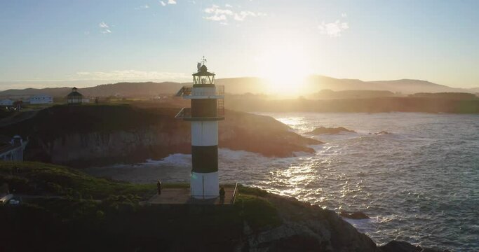 Drone video of lonely lighthouse in sunset on the coast of Galicia, Spain. Island of Pancha (Isla Pancha) clote to Ribadeo village