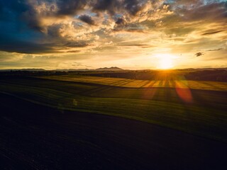 Aerial view of meadows, forest during sunset.