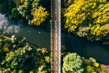 Aerial view of big metal railway bridge in Slovakia, in the middle of summer forest.