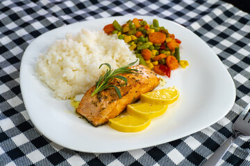 Fried salmon steak with lemon rice and vegetables