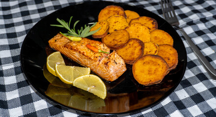 Fried salmon steak with lemon and fried sweet potato