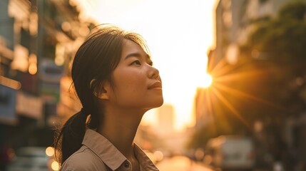 early adulthood Asian woman looks up, dressed in smart casual. backdrop with flare light