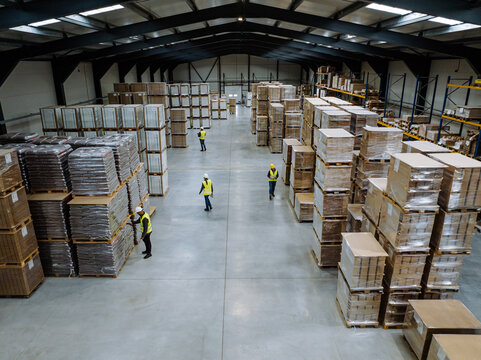 Top view of workers modern warehouse storage of retail shop, large factory workshop space. Employees in modern industrial factory with warehouse.