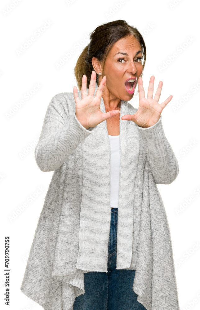 Poster beautiful middle age adult woman wearing winter sweater over isolated background afraid and terrifie