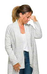 Beautiful middle age adult woman wearing winter sweater over isolated background tired rubbing nose and eyes feeling fatigue and headache. Stress and frustration concept.