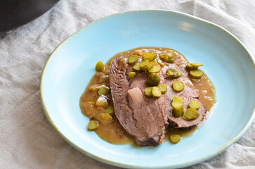 Beef stewed with pickled cucumbers on a blue plate