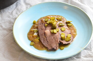Beef stewed with pickled cucumbers on a blue plate