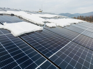 Roof solar panels with snow on top of them. Solar energy in winter.