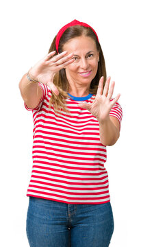 Beautiful middle age woman wearing casual stripes t-shirt over isolated background Smiling doing frame using hands palms and fingers, camera perspective