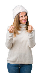 Beautiful middle age woman wearing winter sweater and hat over isolated background Doing money gesture with hand, asking for salary payment, millionaire business