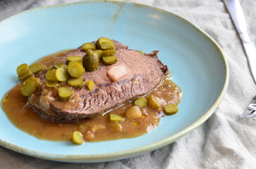 Beef stewed with pickled cucumbers on a blue plate