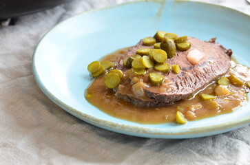 beef filet mignon with sauce and pickled cucumber