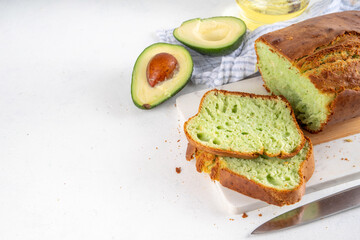 Homemade avocado loaf of bread, keto diet recipe, healthy alternative food idea, on white kitchen background with fresh avocado, copy space
