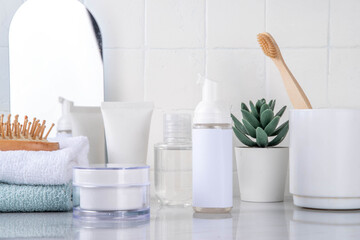 Skinimalism, skin minimalism skin care routine with washing gel, sun protection spf cream, serum bottles and jars on minimal white bathroom background copy space