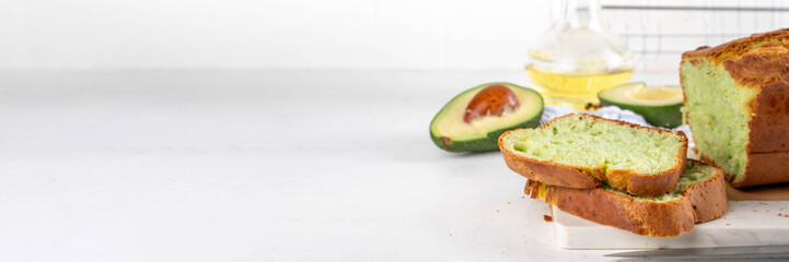 Homemade avocado loaf of bread, keto diet recipe, healthy alternative food idea, on white kitchen background with fresh avocado, copy space