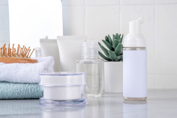 Skinimalism, skin minimalism skin care routine with washing gel, sun protection spf cream, serum bottles and jars on minimal white bathroom background copy space