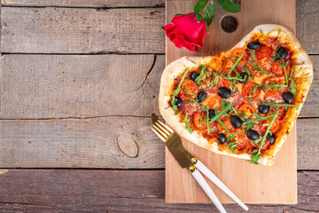 Valentines day heart shaped pizza, love and dating concept with mozzarella. tomatoes, pepperoni and...