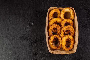 Delicious fast food fried onion rings in a cardboard box for takeaway