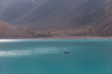 Boat on the lake. Kol Tor lake, a lake in the mountains. Two persons in the little boat.