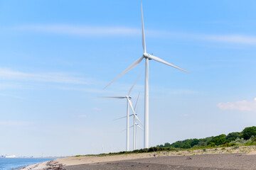 Wind turbines along a coast on a clear summer day
