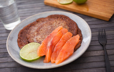 Salted salmon fillet with buckwheat pancakes and lime