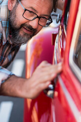 Close up of man having car of his new car. Vehicle lovers concept with male people checking shiny and polish - owner or mechanic with automobile . Transportation concept and dreaming adult