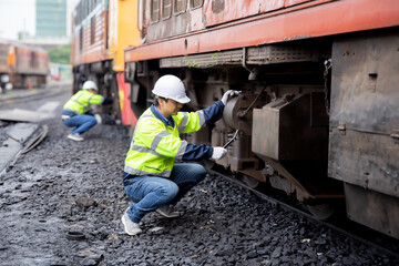 Young caucasian engineer man maintenance and repair train diesel engine in station, team engineer inspect system transport, technician checking infrastructure, transportation and industry.