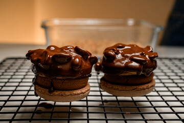 Close-up of two brown macaroons decorated with nuts and chocolate cream