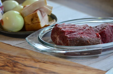 Raw meat in a glass jar on the kitchen table. Selective focus.