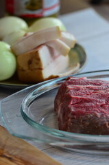 Raw meat in a glass jar on the kitchen table. Selective focus.