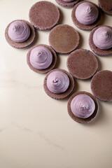 Close-up of round halves of macaroon with purple cream