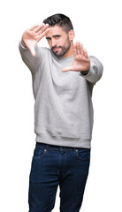 Young handsome man wearing sweatshirt over isolated background Smiling doing frame using hands palms and fingers, camera perspective