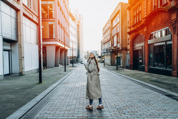 smiling young woman  having a fun time,  using phones, reaching hir destination outdoor in a urban winter city. people, communication,  shopping and lifestyle concepts