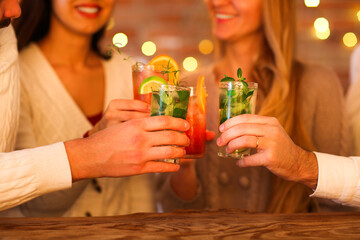 Young men and women drinking cocktail at party