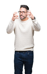 Young handsome man wearing glasses over isolated background Shouting frustrated with rage, hands trying to strangle, yelling mad