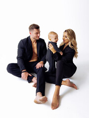 Man and Woman Sitting on Floor With Baby - Family Bonding Time. A man and woman are bonding with their baby as they sit together on the floor.