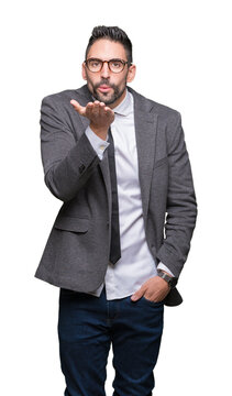Young handsome business man over isolated background looking at the camera blowing a kiss with hand on air being lovely and sexy. Love expression.