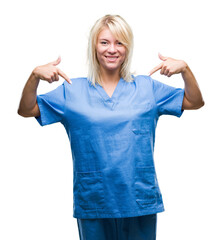 Young beautiful blonde nurse doctor woman over isolated background looking confident with smile on...