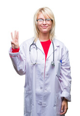 Young beautiful blonde doctor woman wearing medical uniform over isolated background showing and pointing up with fingers number three while smiling confident and happy.