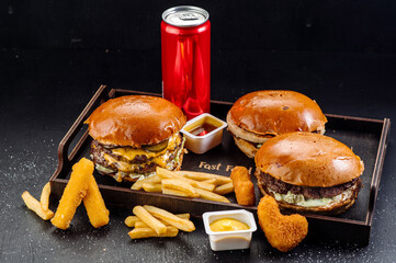 Tasty big burger and fries with can of cola on wooden background. Takeaway fast food - 709838364