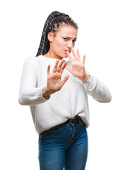 Young braided hair african american girl wearing winter sweater over isolated background disgusted expression, displeased and fearful doing disgust face because aversion reaction. With hands raised.