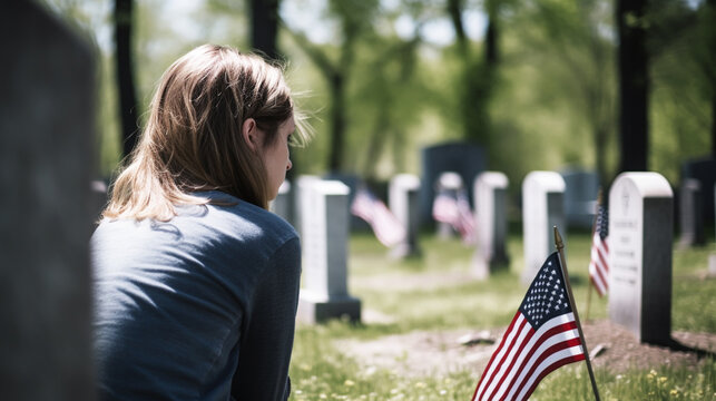 Woman praying in a memorial cemetery, for war soldiers