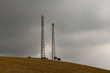 Communication tower in field with dark storm clouds
